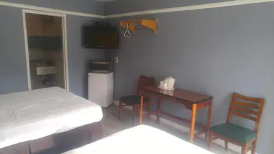 a bedroom with a bed and a table and chairs at Riviera Motel in Anaheim
