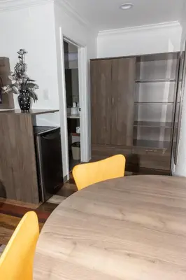 a dining room with a table and yellow chairs at Value Inn Bellflower in Bellflower