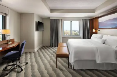a hotel room with a large bed and a desk at The Westin Pasadena in Pasadena