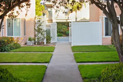 a garden with a white fence and grass at Channel Island Shores in Oxnard