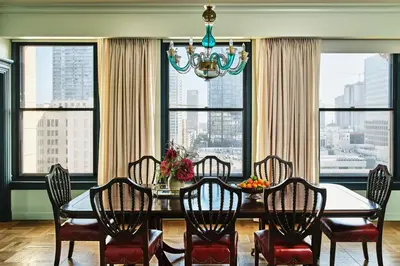 a dining room with a table and chairs and windows at Hotel Per La, Autograph Collection in Los Angeles