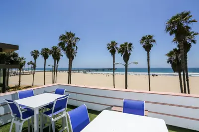 a patio with tables and chairs and the beach at Venice on the Beach Hotel in Los Angeles