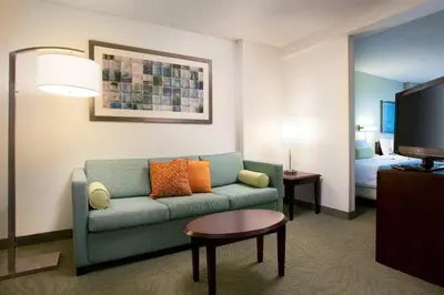 a living room with a couch and a tv at SpringHill Suites Los Angeles LAX/Manhattan Beach in Hawthorne