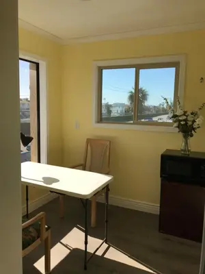 a dining room with a table and two windows at 777 Motor Inn in Huntington Beach
