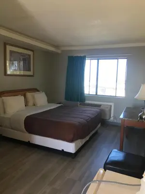 a bedroom with a large bed and a window at 777 Motor Inn in Huntington Beach