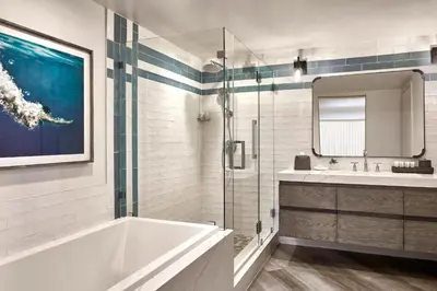 a bathroom with a tub and a sink and a mirror at Westdrift Manhattan Beach, Autograph Collection in Manhattan Beach