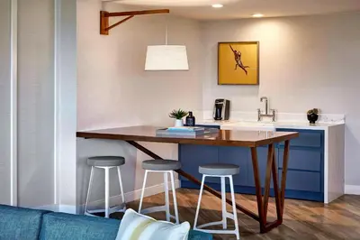 a kitchen with a table and two bar stools at Westdrift Manhattan Beach, Autograph Collection in Manhattan Beach