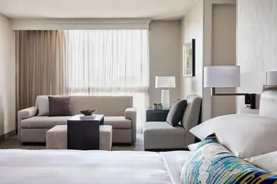 a hotel room with a bed and a couch and a chair at Los Angeles Airport Marriott in Los Angeles