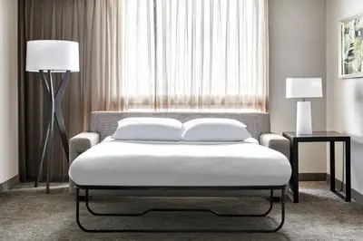 a bedroom with a bed and two lamps and a window at Los Angeles Airport Marriott in Los Angeles