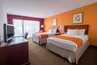 a hotel room with two beds and a flat screen tv at Howard Johnson by Wyndham Fullerton/Anaheim Conference Cntr in Fullerton