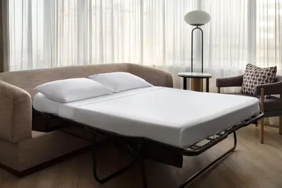 a bed in a room with a couch and a chair at Marriott Long Beach Downtown in Long Beach