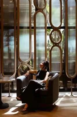 a woman sitting in a chair in a room with windows at Marriott Long Beach Downtown in Long Beach