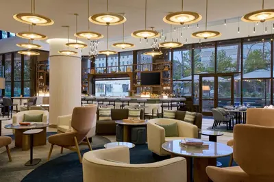 a lobby with tables and chairs and a bar at Marriott Long Beach Downtown in Long Beach