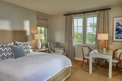 a bedroom with a large bed and a desk and chairs at Terranea Resort in Rancho Palos Verdes