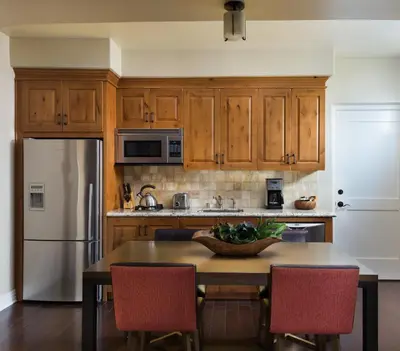 a kitchen with wooden cabinets and a table with chairs at Terranea Resort in Rancho Palos Verdes