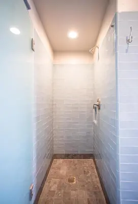 a bathroom with a shower with blue tiles at Ocean Park Hotel in Los Angeles