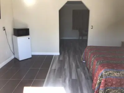 a hotel room with a bed and a refrigerator at Galleria Inn Montclair/Ontario in Montclair