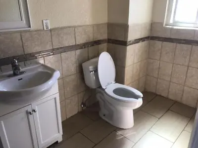 a bathroom with a toilet and a sink at Galleria Inn Montclair/Ontario in Montclair