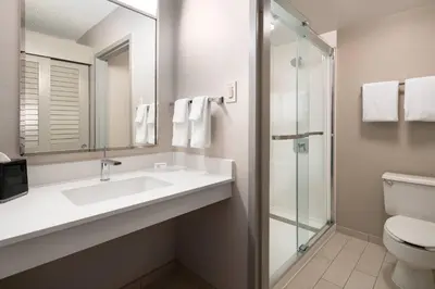 a bathroom with a sink and a toilet and a mirror at Courtyard by Marriott Bakersfield in Bakersfield