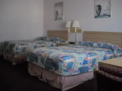 a hotel room with two beds and a table at Palms Courtyard Inn in Westminster