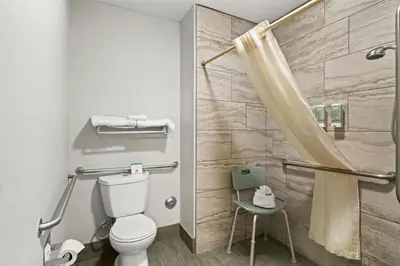 a bathroom with a toilet and a shower at Best Western Desert Villa Inn in Barstow