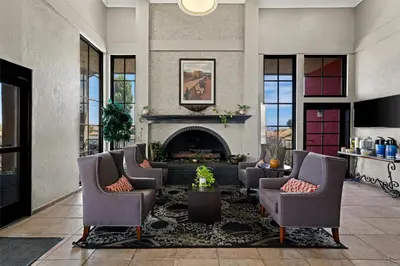 a living room with chairs and a fireplace at Best Western Desert Villa Inn in Barstow