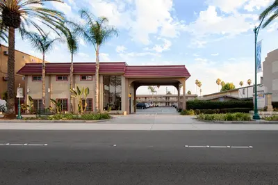 a building with palm trees in front of a street at Anaheim Discovery Inn and Suites in Anaheim