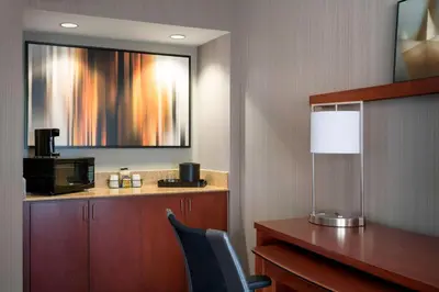 a hotel room with a desk and a microwave at Sonesta Select Los Angeles Torrance South Bay in Torrance
