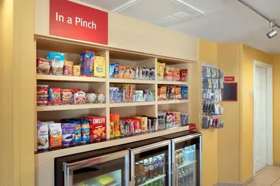 a store aisle with a refrigerator and shelves of food at TownePlace Suites Los Angeles LAX Manhattan Beach in Hawthorne
