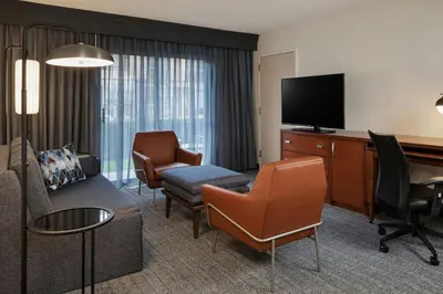 a hotel room with a living area with a flat screen tv at Courtyard Anaheim Buena Park in Buena Park