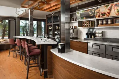 a bar in a restaurant with a counter and bar stools at Courtyard Anaheim Buena Park in Buena Park