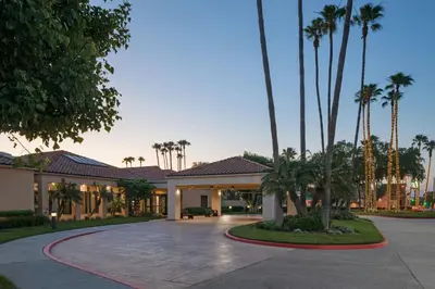 a home with palm trees and a driveway at Courtyard Anaheim Buena Park in Buena Park