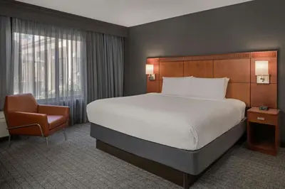 a hotel room with a bed and a chair at Courtyard Anaheim Buena Park in Buena Park