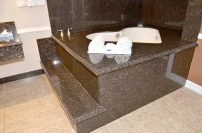 a bathroom with a sink and towels on a counter at Dynasty Suites Hotel in Riverside