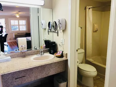 a bathroom with a sink and a toilet and a mirror at Dynasty Suites Hotel in Riverside