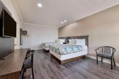 a hotel room with a bed and a desk and a tv at Motel 6 South Gate CA in South Gate