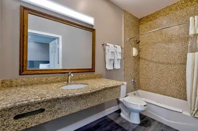 a bathroom with a sink and a toilet and a tub at Motel 6 South Gate CA in South Gate