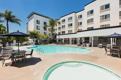 a pool at a hotel with tables chairs and umbrellas at Courtyard by Marriott Anaheim Resort/Convention Center in Anaheim