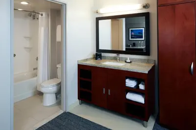 a bathroom with a sink and a mirror and a toilet at Courtyard by Marriott Los Angeles LAX / Century Boulevard in Los Angeles