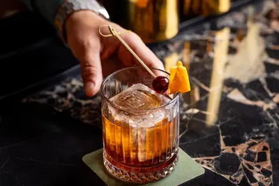 a person holding a drink with a cherry on top at Burton House, Beverly Hills, A Tribute Portfolio Hotel in Los Angeles