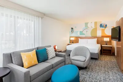a hotel room with a couch and a bed at Clementine Hotel & Suites Anaheim in Anaheim