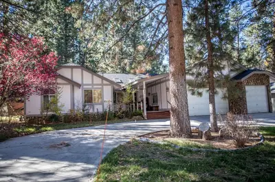 a house with a tree in front of a driveway at Majestic Pines Home in Big Bear Lake