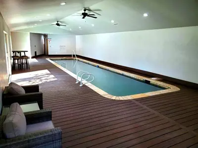 a large swimming pool in a living room with a ceiling at Big Bear Splash Home in Big Bear Lake
