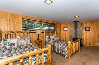 two beds in a room with wooden walls at Big Bear Splash Home in Big Bear Lake