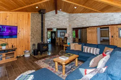 a living room with a blue couch and a table at Big Bear Splash Home in Big Bear Lake