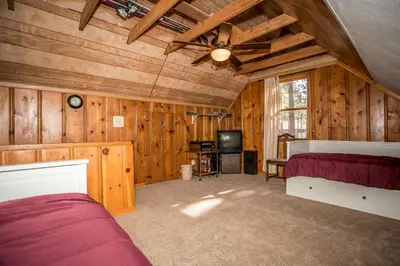 a bedroom with wooden walls and a ceiling at Mountain Air Home in Big Bear Lake