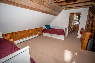 a attic room with a bed and a window at Mountain Air Home in Big Bear Lake