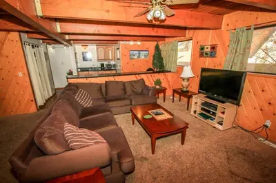 a living room with a couch and a flat screen tv at Family Fun House in Big Bear Lake