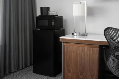 a room with a microwave and a desk with a chair at Courtyard Los Angeles Burbank Airport in Burbank