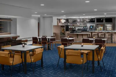 a dining room with tables and chairs and a bar at Courtyard by Marriott Santa Clarita Valencia in Valencia